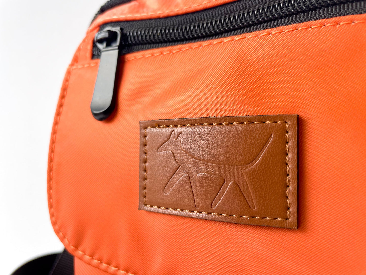 Detail of the Droggo logo on the walking bag in rust colour.