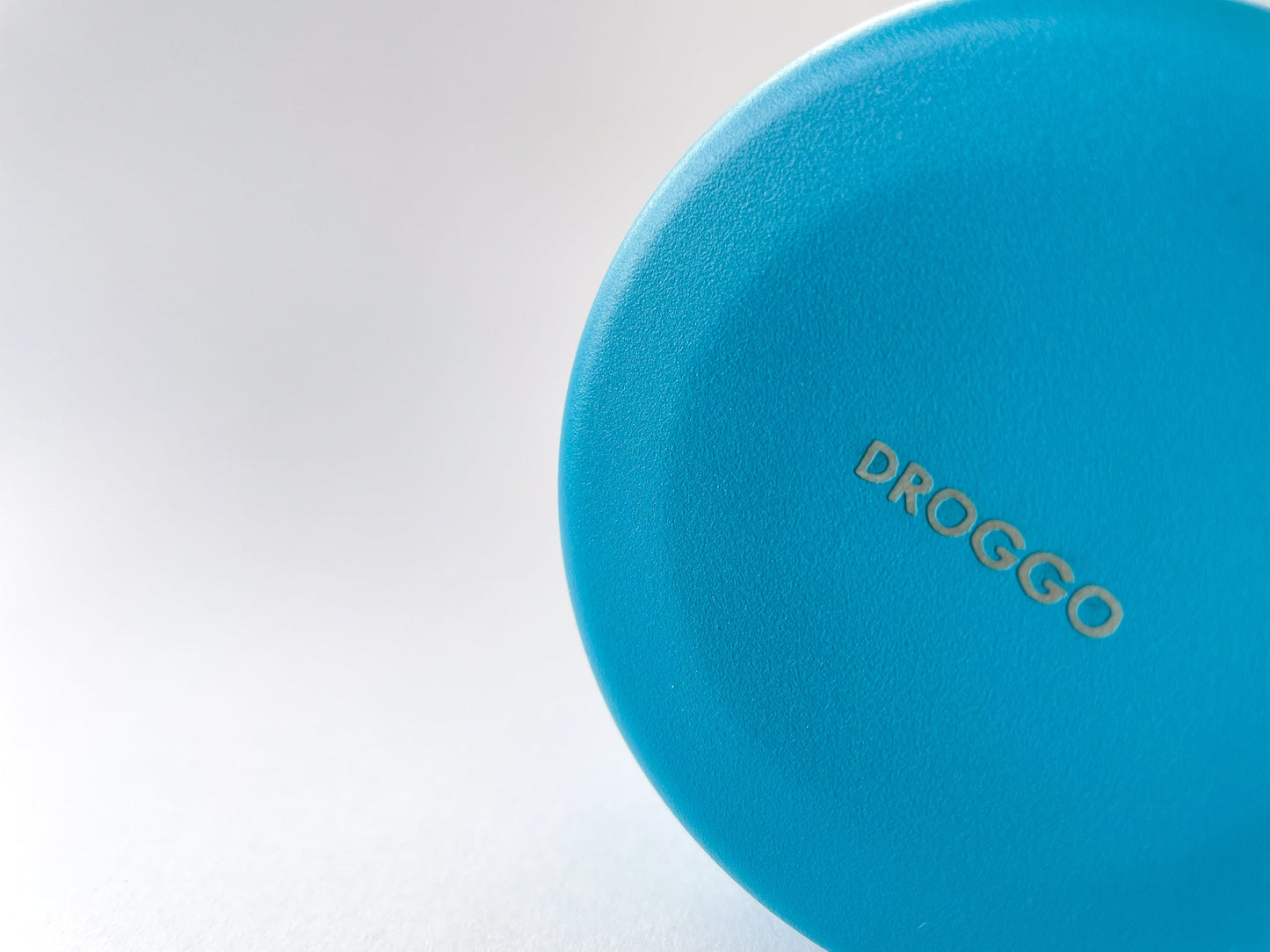 Detail of the Droggo logo at the bottom of the lake water bottle. White background.