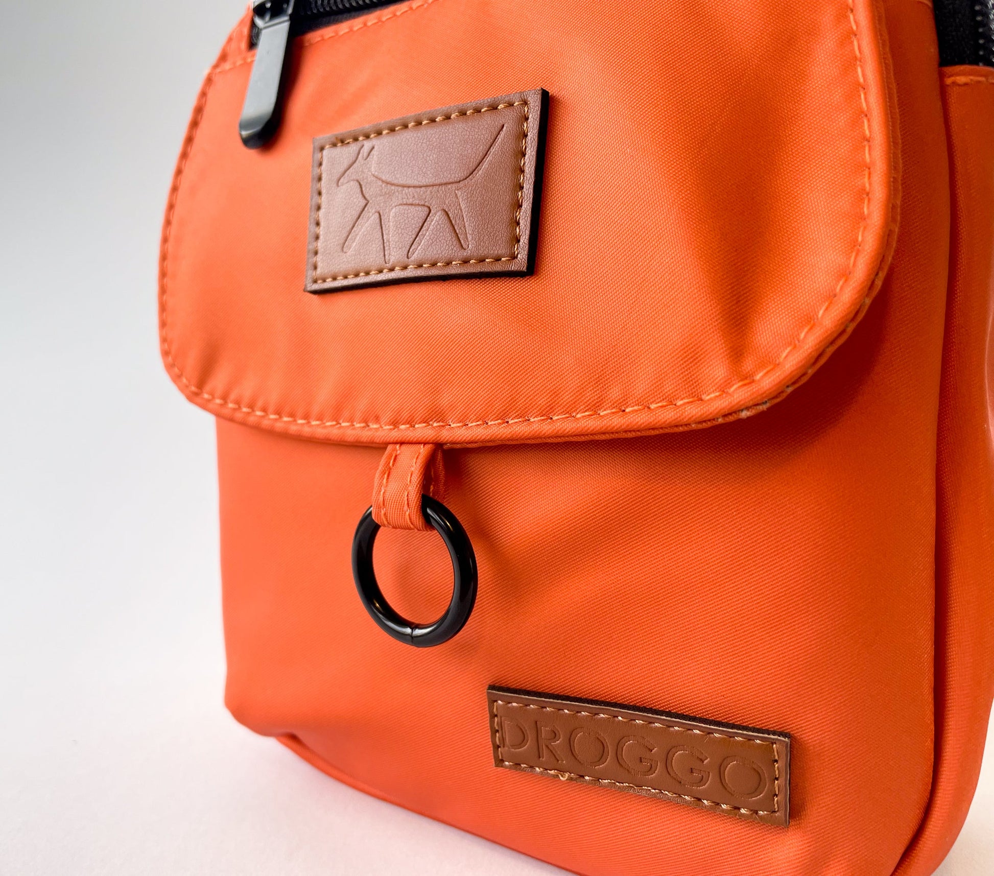 Detail of the Droggo logos on the walking bag in rust colour.