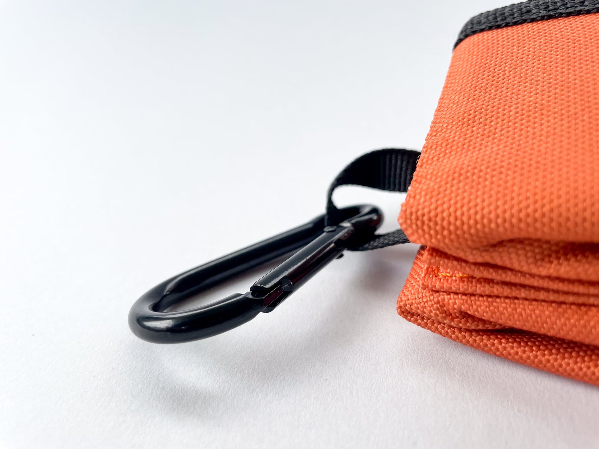 Carabiner detail of the dog travel bowl in rust colour. White background.