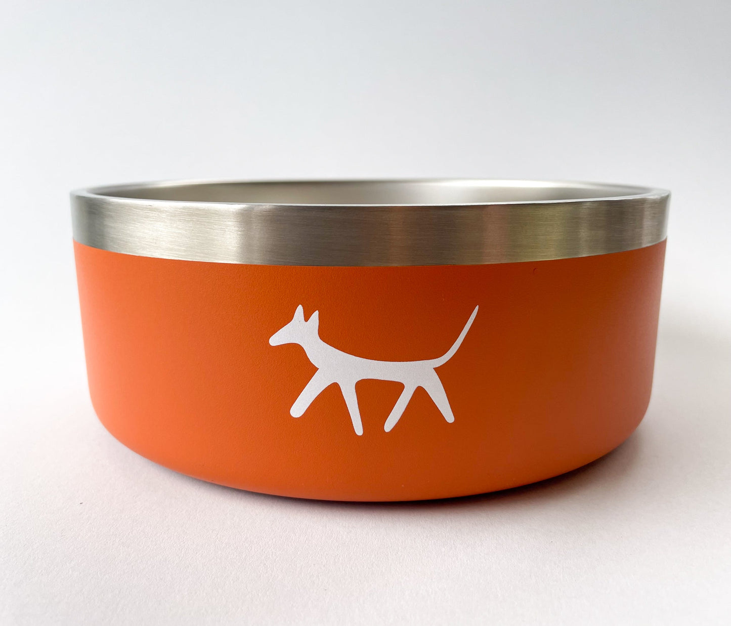 Close up of stainless steel dog bowl in rust colour with cream Droggo logo on the front. White background.