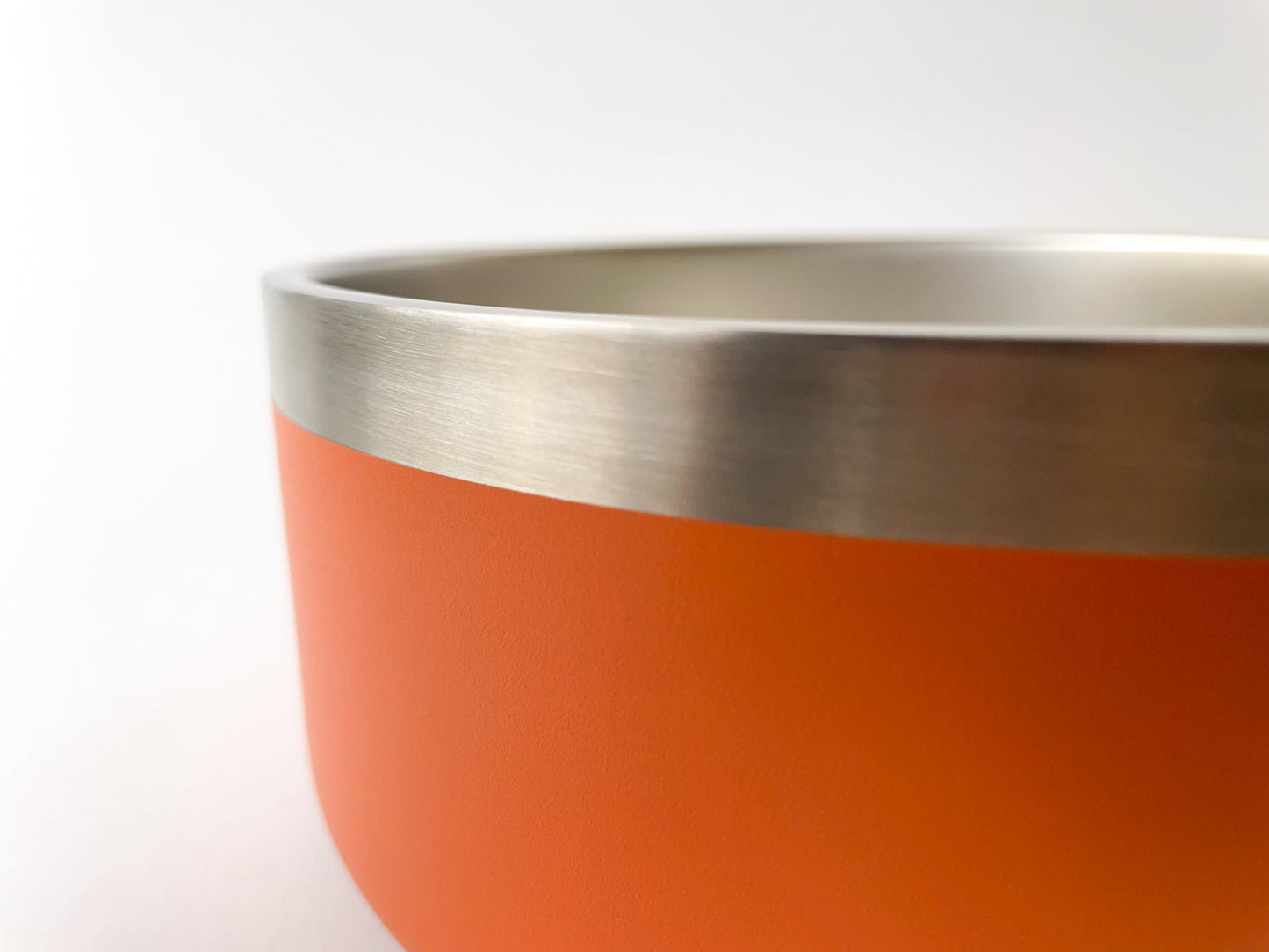 Close up of the stainless steel dog bowl in rust colour. White background.