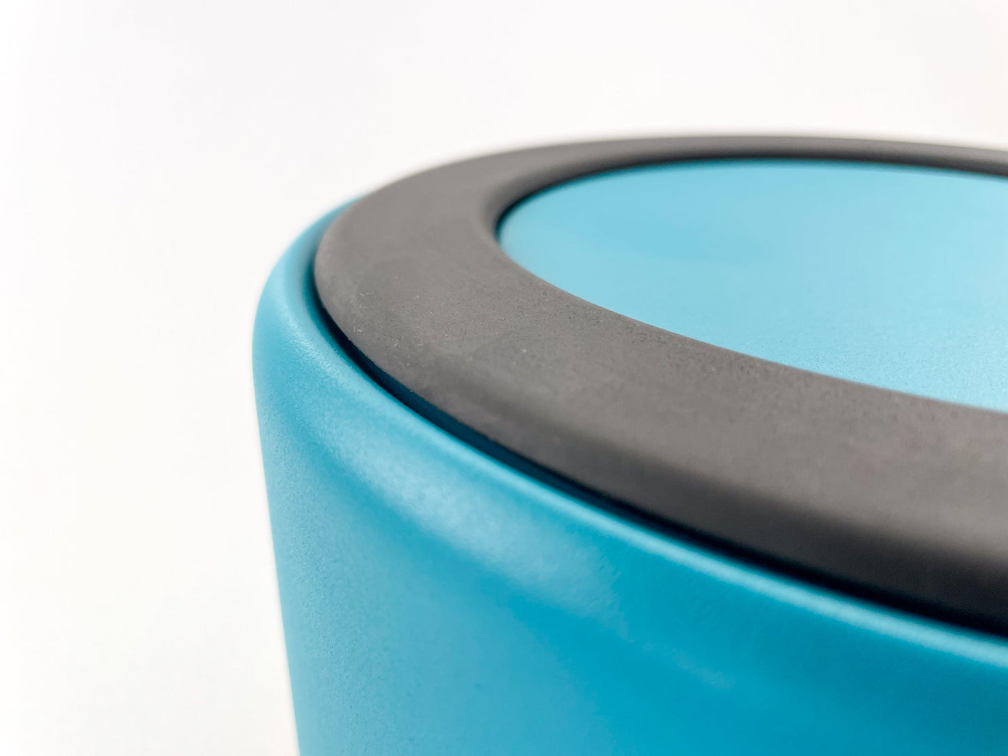 Detail of the anti slip rubber at the bottom of the stainless steel dog water bowl in lake colour. White background.