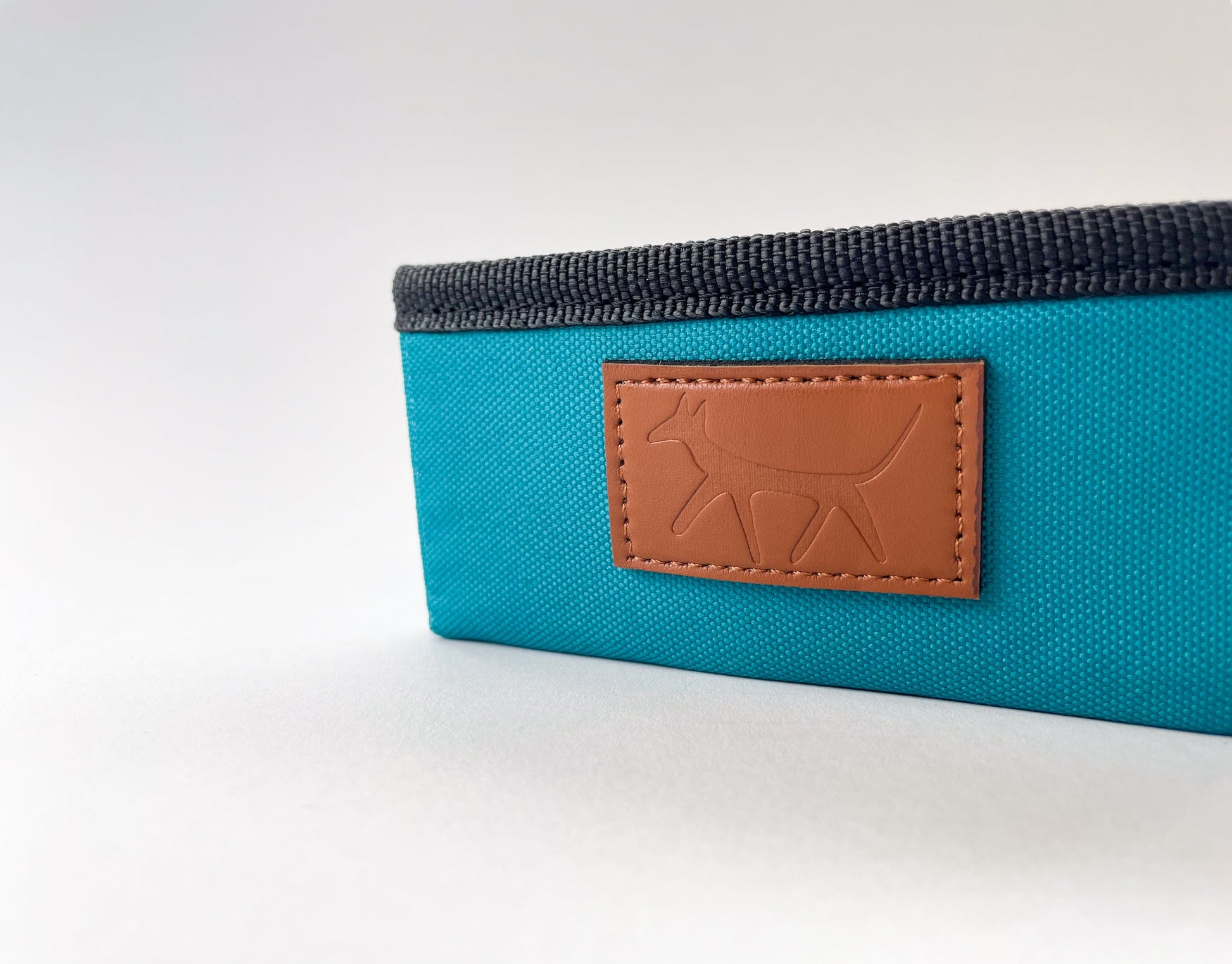 Detail of the leather Droggo logo on the dog travel bowl in lake colour.