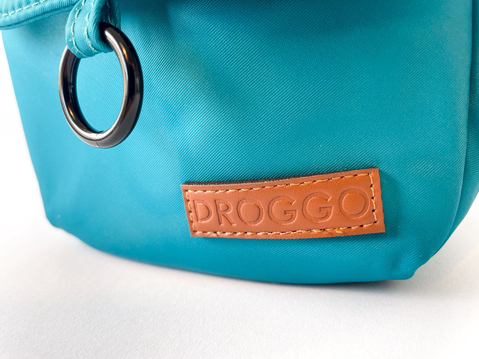 Detail of the leather Droggo logo on the dog walking bag in lake colour.