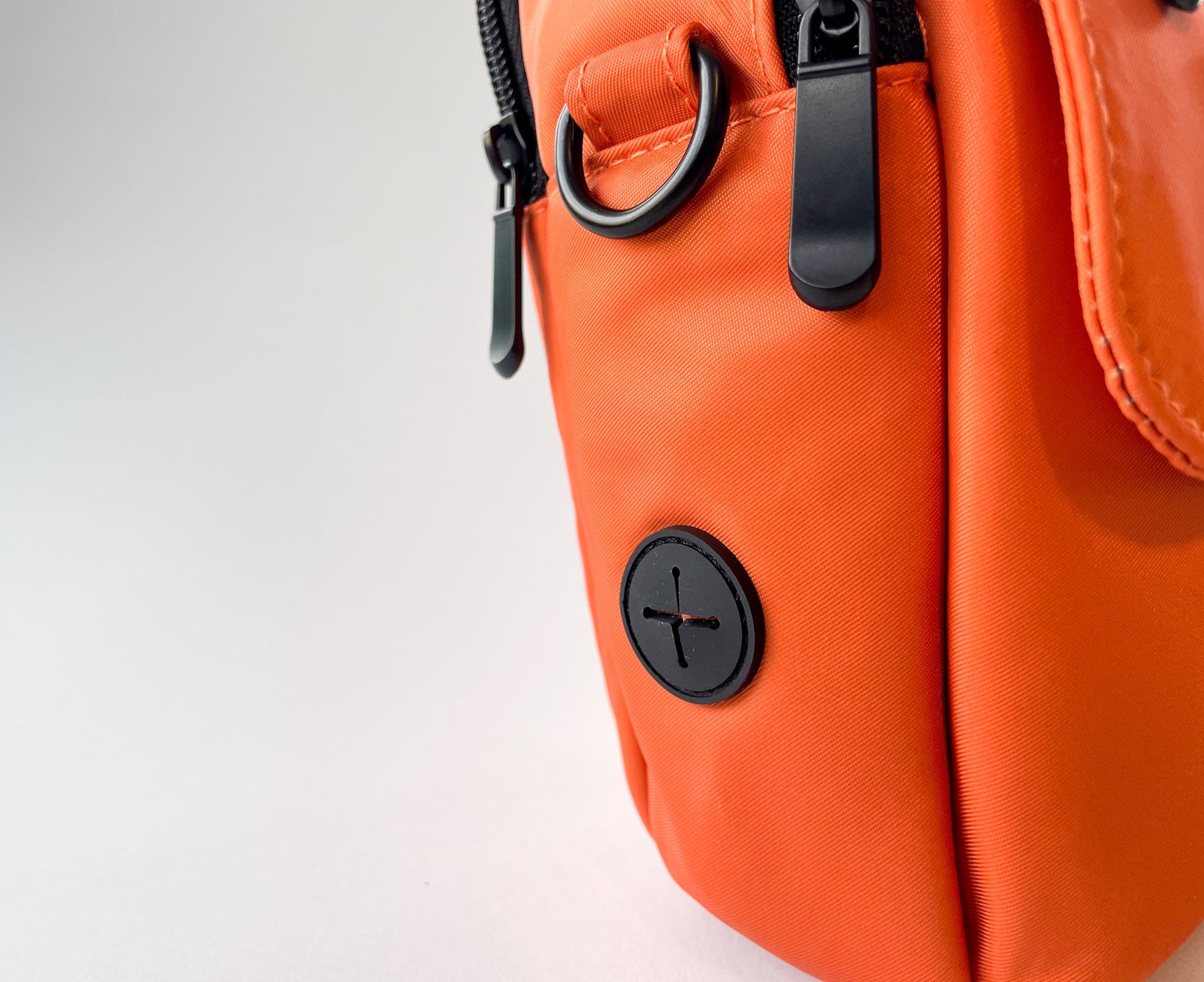 Detail of the poop bag holder on the dog walking bag in rust colour.