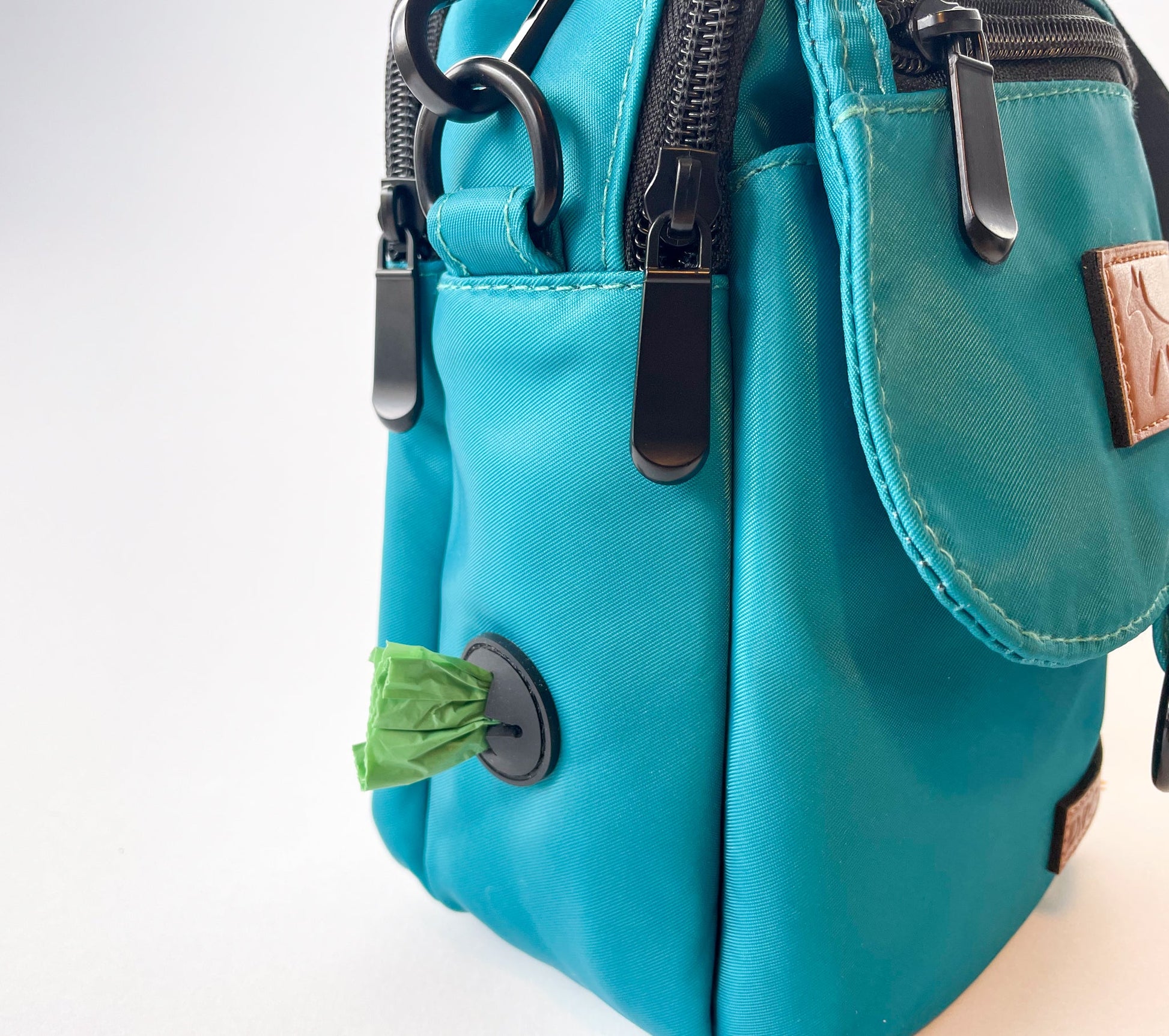 Detail of the poop bag holder on the dog walking bag in lake colour.